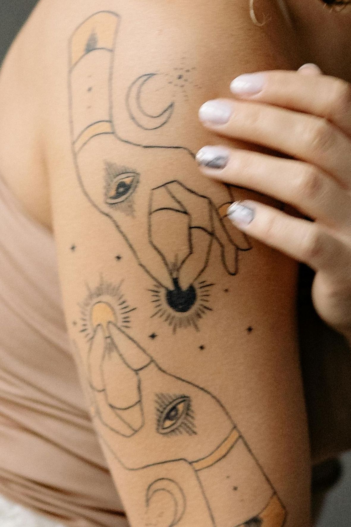 Tatouage artistique aux lignes fines et symboles sur le bras d’une personne dans l’univers du tatouage  à Moncton